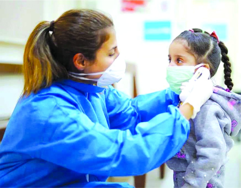 護士在疫情期間為一名女孩測量體溫。