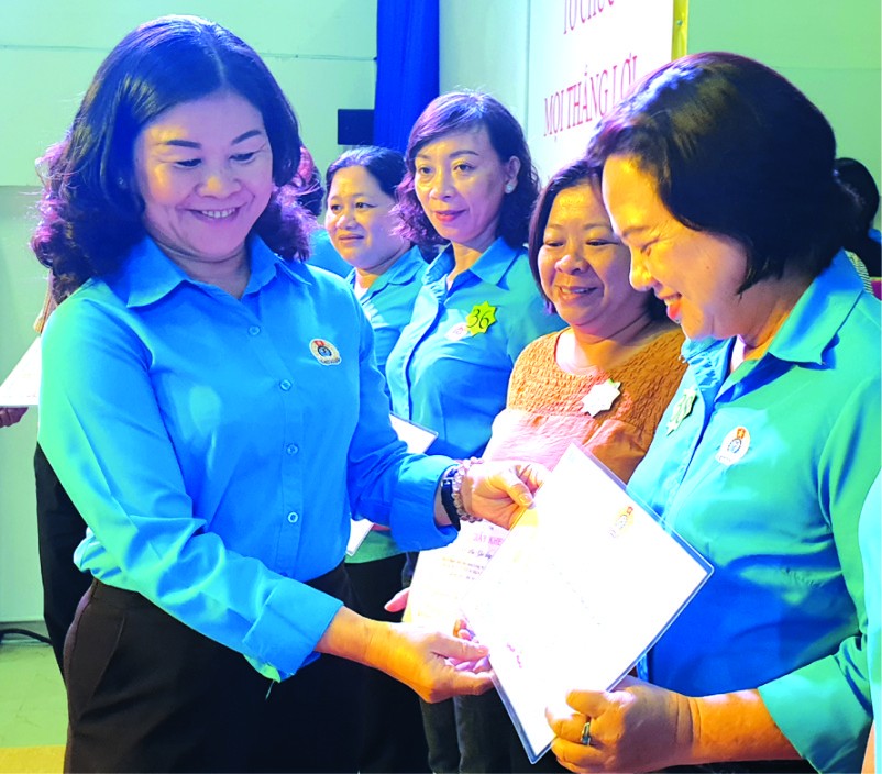 第五郡勞動聯團主席黎氏碧幸向女職工頒發模範獎。