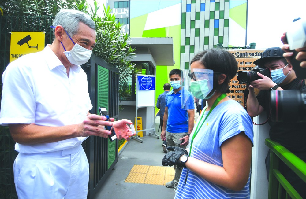 新加坡總理李顯龍（左）來到一處投票站投票。