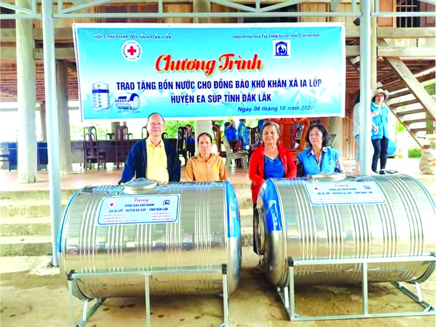 穗城會館理事長盧耀南(左一)向貧困戶 移交不鏽鋼水塔。