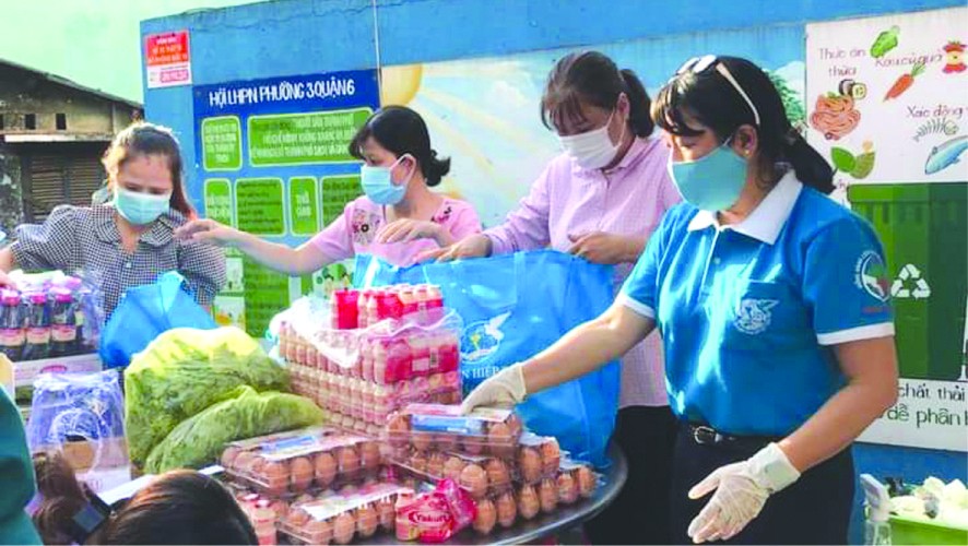 第六郡婦聯會主席梁氏菁竹(右一) 親自給隔離居民派發應用品。