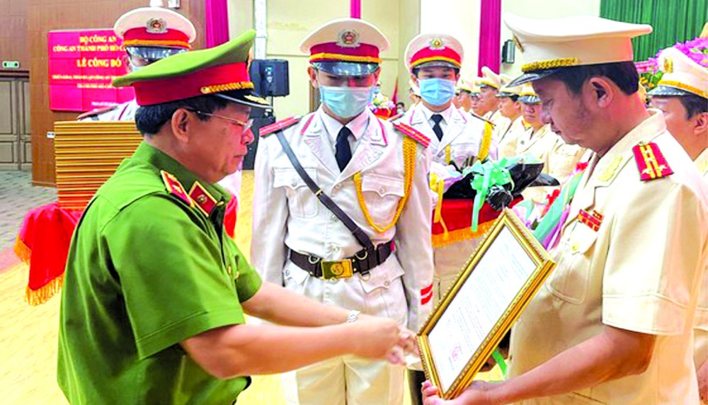 市公安廳副廳長給阮煌勝大校頒授《決定》。