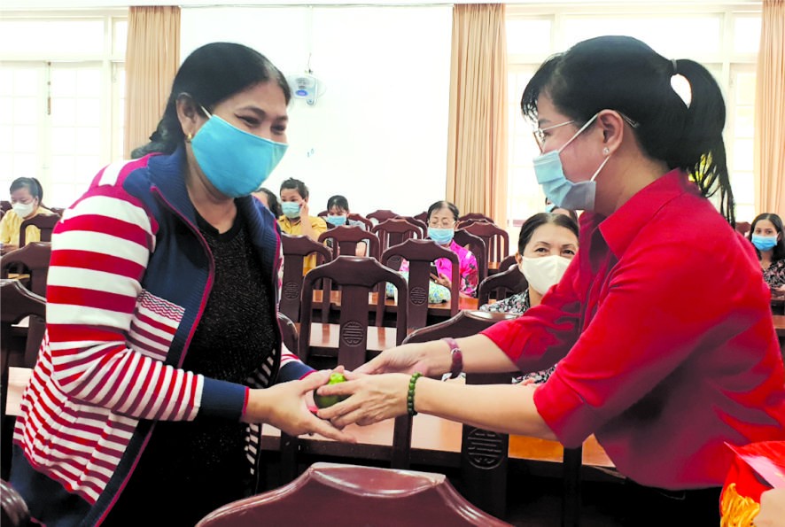 郡婦聯會主席陳氏雪幸(右)向各民族 婦女派發紅包。