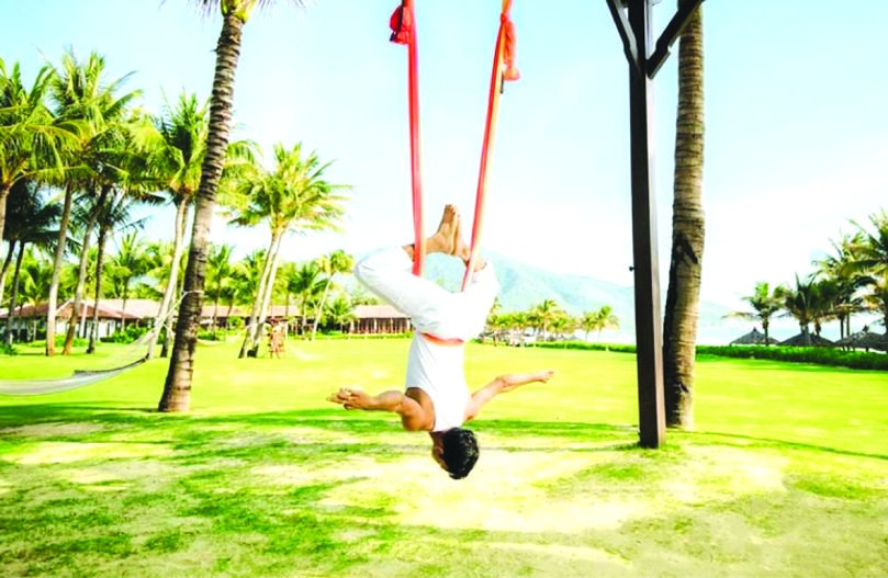 這是使用一條獲掛在戶外的綢帶來練習各式瑜伽姿態