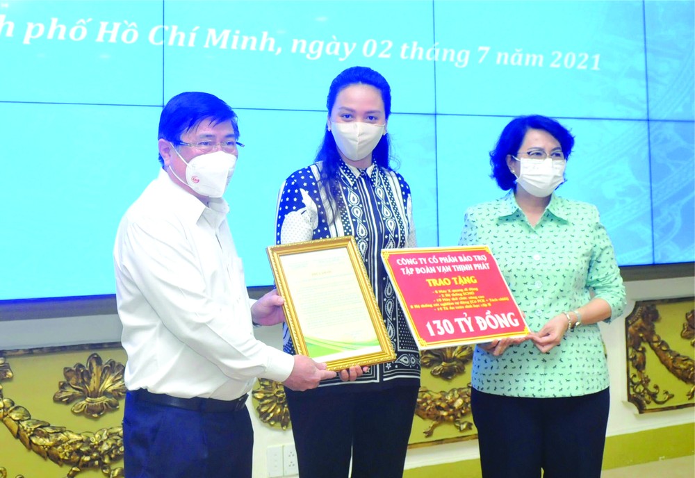 萬盛發集團總經理張惠雲(中)向市人委會主席阮成鋒和市越南祖國陣線委員會主席蘇氏碧珠遞交1300億元善款。