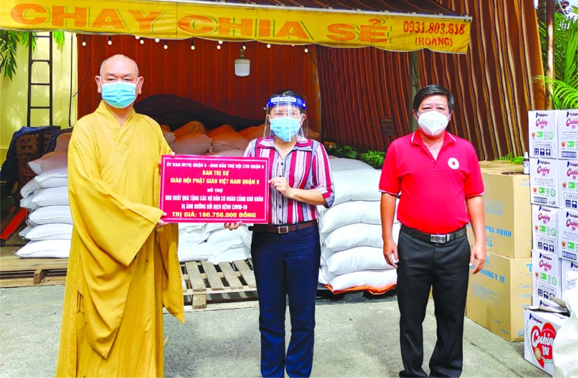 　　范氏明月副主席接受郡佛教會會長 釋慧功法師轉交的物資。