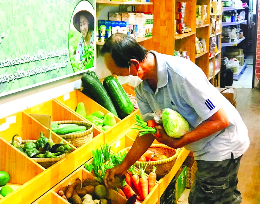 顧客在“家鄉市集”綠色產品商店購買蔬菜。