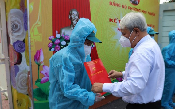 第七郡郡委書記武克泰在富順幼兒園隔離點向新黨員頒發入黨《決定》。