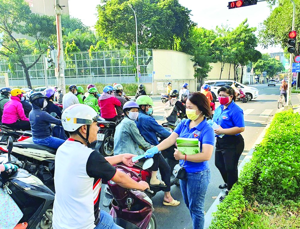 共青團員、青年向民眾派發口罩與 5K 防疫措施傳單。