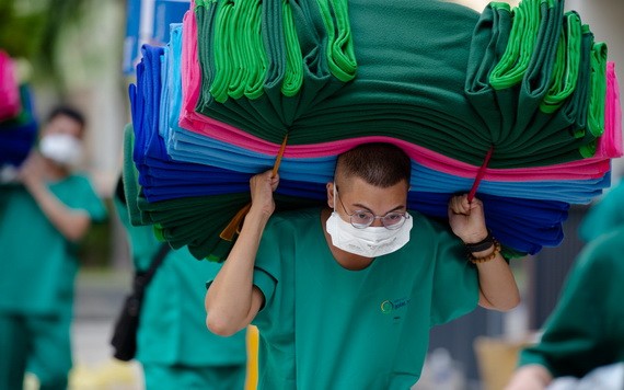 第二郡6號新冠肺炎野戰醫院醫護人員背著沉重的物資進入治療、隔離區。