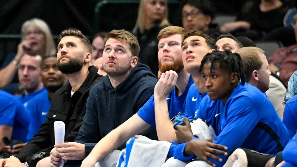 Doncic (áo đen) đang theo dõi một trận đấu của đội nhà trên băng ghế dự bị