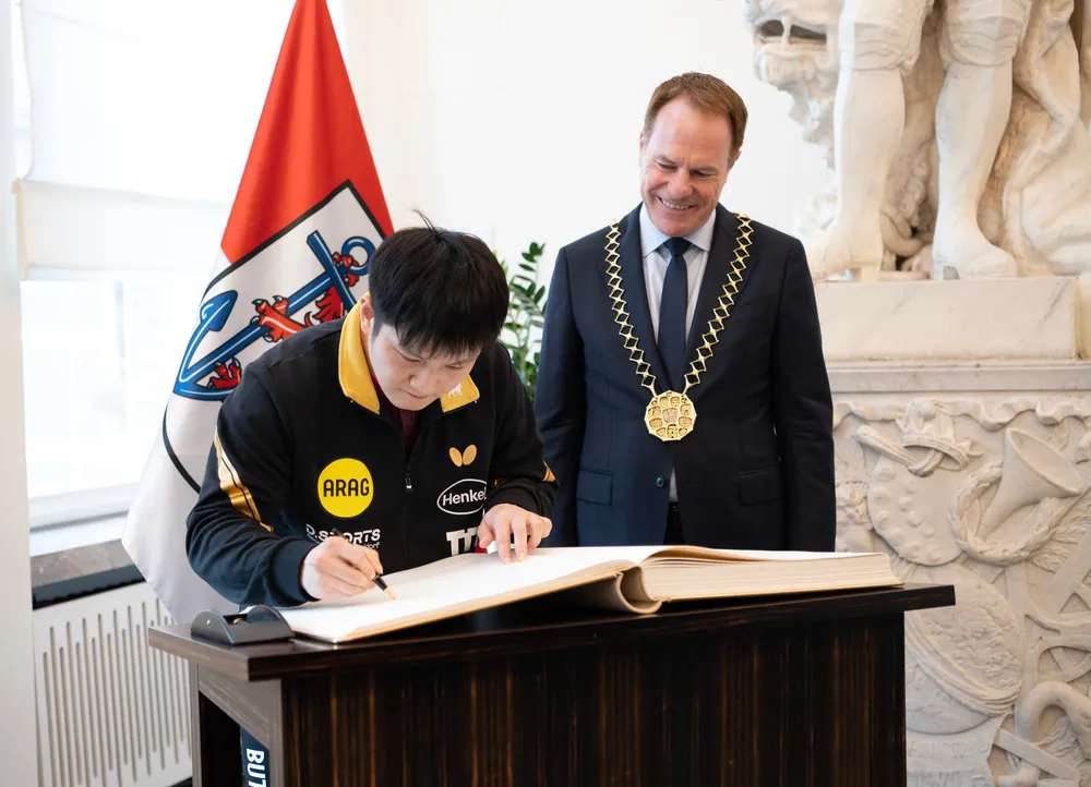 Fan Zhendong đặt bút ký vào Sổ Vàng.JPG