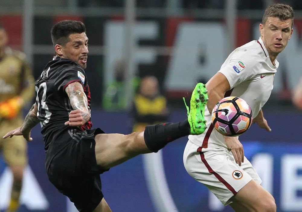 Edin Dzeko (phải, Roma) tranh bóng với hậu vệ Jose Sosa (Milan). Ảnh: Getty Images.