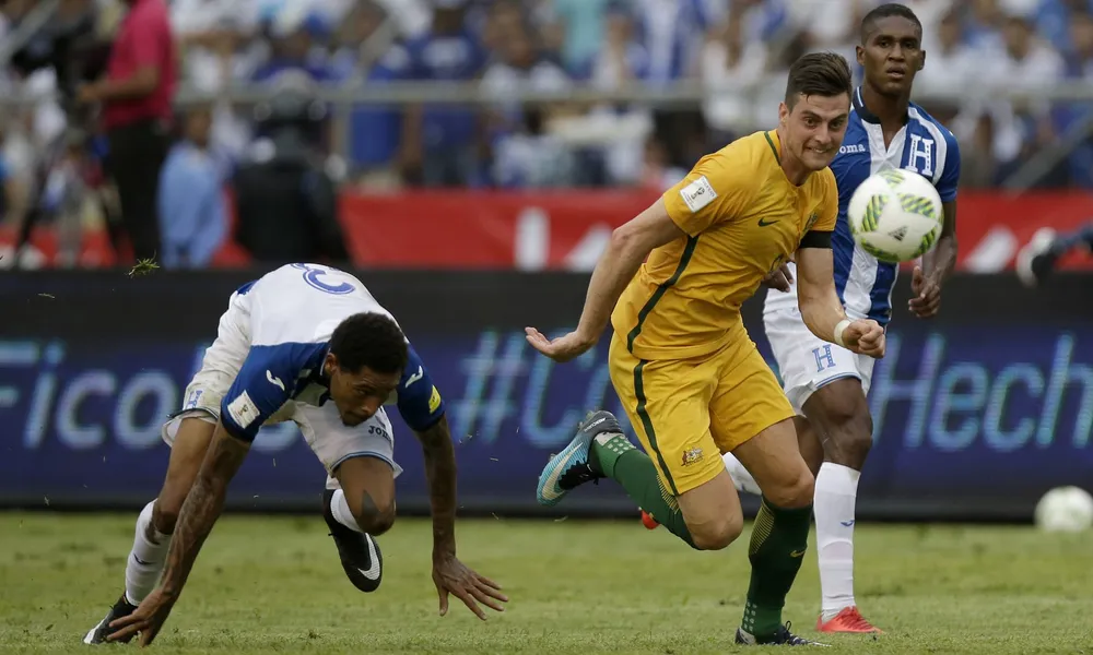 Tiền đạo Tomi Juric (phải, Australia) bỏ rơi hậu vệ Honduras dễ dàng nhưng lại sút chệch cột. Ảnh: AP.