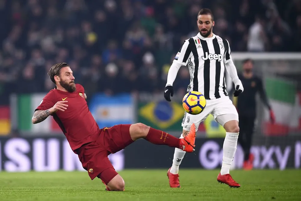 Gonzalo Higuain (phải, Juventus) tranh bóng với Daniele De Rossi (AS Roma). Ảnh: Getty Images.