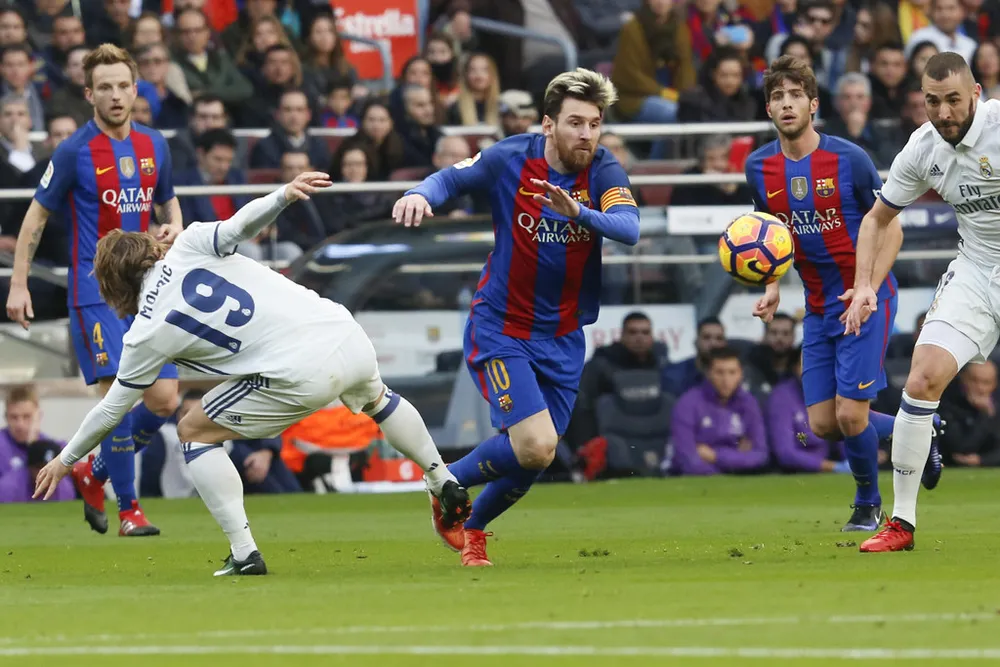 Lionel Messi (Barcelona) vượt qua Luka Modric (trái, Real Madrid). Ảnh: Getty Images