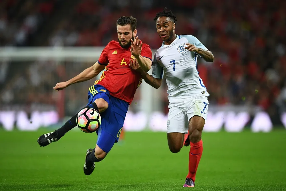 Raheem Sterling (Anh) tranh bóng với Nacho (Tây Ban Nha. Ảnh: Getty Images.