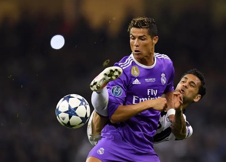 Cristiano Ronaldo (trái) tranh bóng vớí hậu vệ Juventus