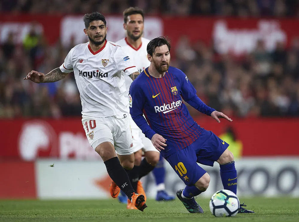 Lionel Messi đi bóng qua Ever Banega (Sevilla)