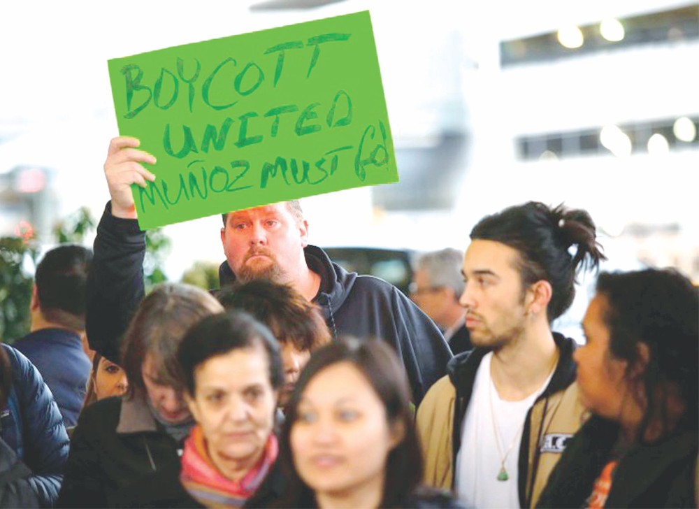 示威者在芝加哥機場高舉標語抗議。