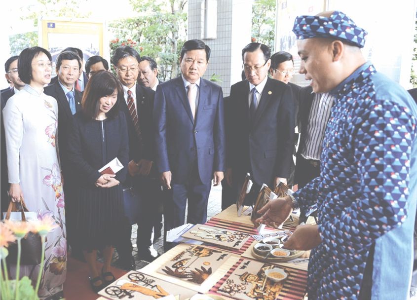 本市高級代表團參觀用大米作畫展位。