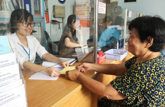 陳氏紅詩熱情地指引現年72歲的阮氏珊辦理申請領取殘疾人士福利卷宗。資料圖：SGGP