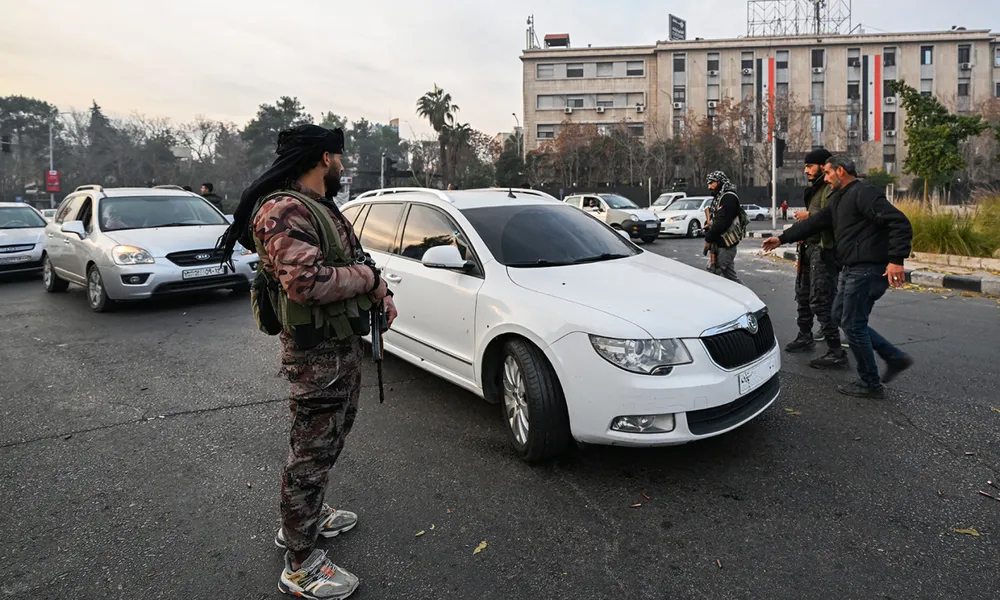 Thành viên HTS đứng gác trên đường phố thủ đô Damascus, Syria ngày 8/12. Ảnh: AFP