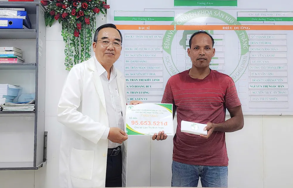 BS.CKII Chung Tấn Định trao tiền hỗ trợ của các mạnh thường quân cho cha của bé T.