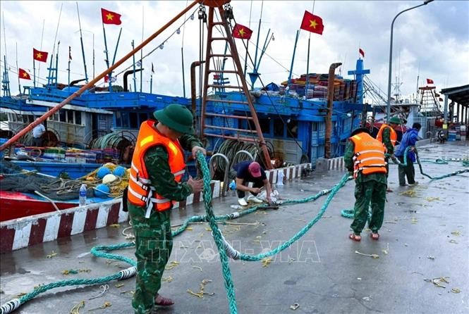 9月27日，炉门-滨水港口边防哨所（义安省边防部队）的干部和战士们协助渔民收拾渔具。