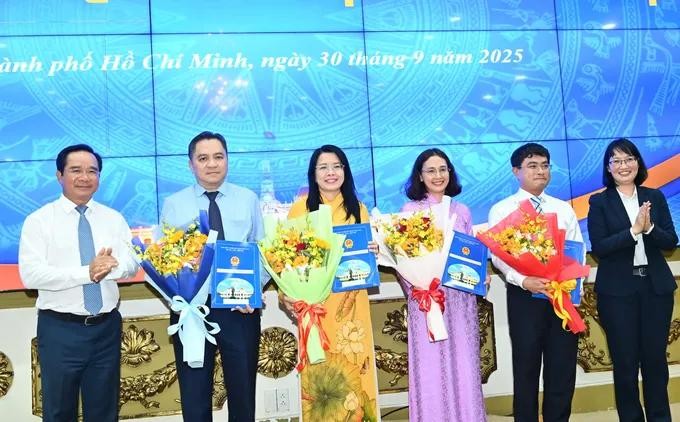 胡志明市人委会主席阮文得和副主席陈氏妙翠向获得委任的个人颁授决定和赠送鲜花表示祝贺。