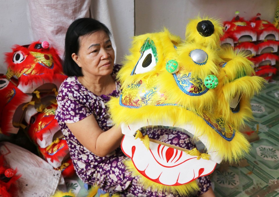 顺化市富春坊的张氏金芝家庭正在赶制小型舞狮狮头投放市场。