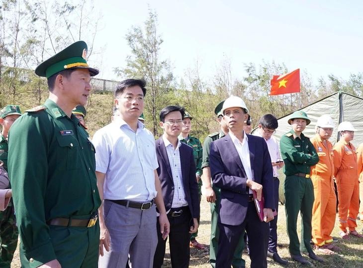 广义省人委会副主席杜心显（左二）检查印有中文字样的船只搁浅现场。