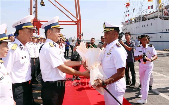 越南海军第二区司令部副参谋长黎廷宜大校（左）向KRI Bima Suci号船长苏庚·哈里扬托中校送花欢迎。