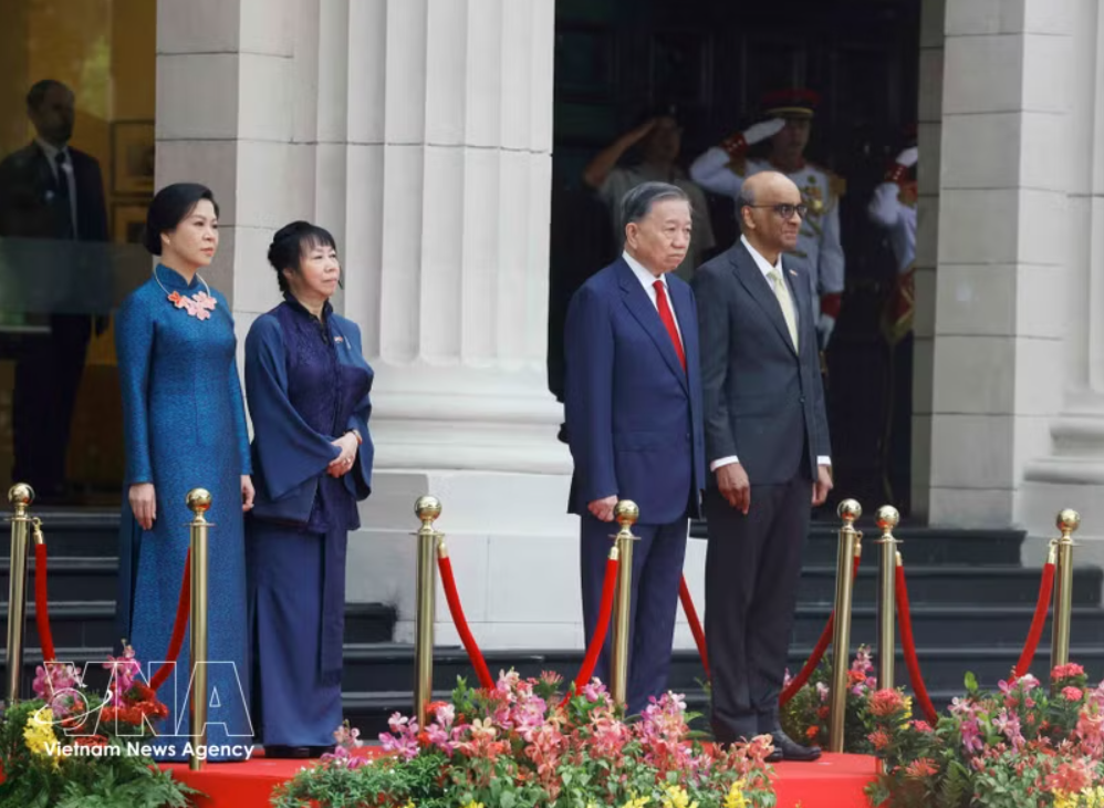 党中央总书记、国家主席苏林与新加坡总统尚达曼在检阅台上，聆听军乐队奏两国国歌。