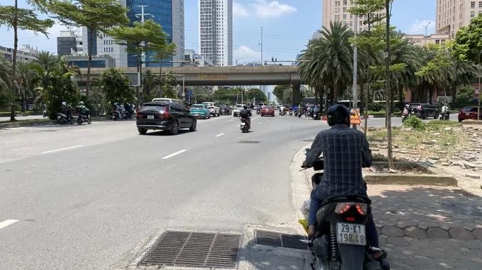 在河内杨廷艺街与环市三路四岔路口等待交通信号灯的交通参与者在树荫下停车躲避烈日。图：福厚