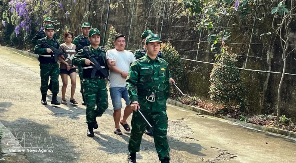 老街国际口岸边防部队押解“LC326”专案2名涉嫌贩运人口犯罪嫌疑人。图片来源：越通社
