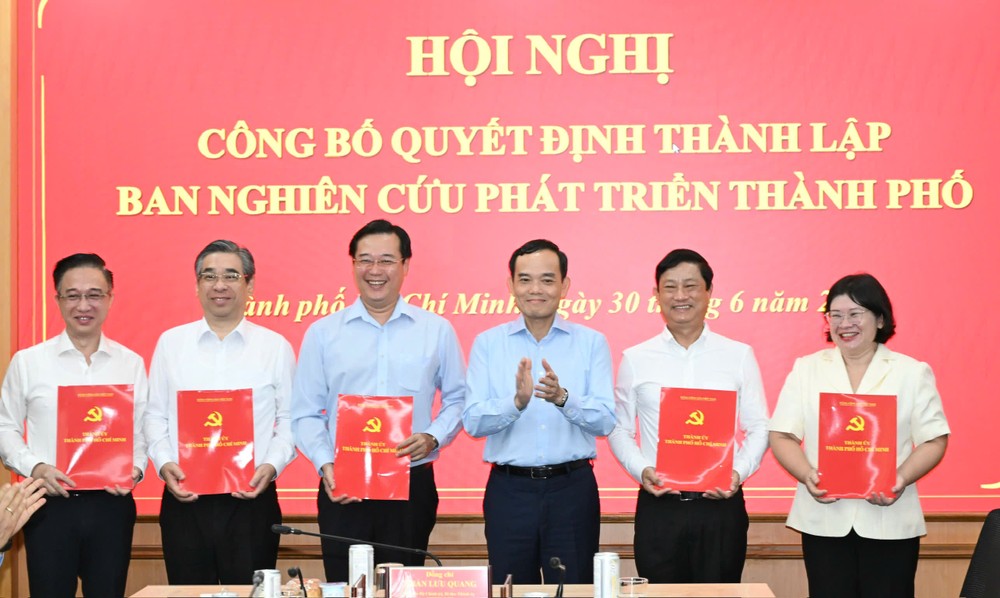 胡志明市市委书记、胡志明市发展研究处主任陈留光向胡志明市发展研究处各位副主任同志颁授决定。图：越勇