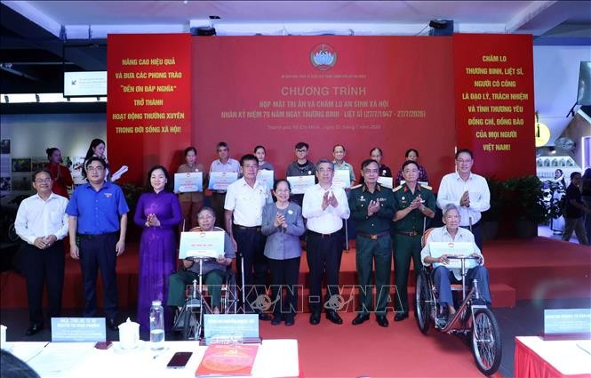 胡志明市市委副书记、市越南祖国阵线委员会主席阮福禄（右四）向优抚政策家庭赠送车辆、谋生工具。