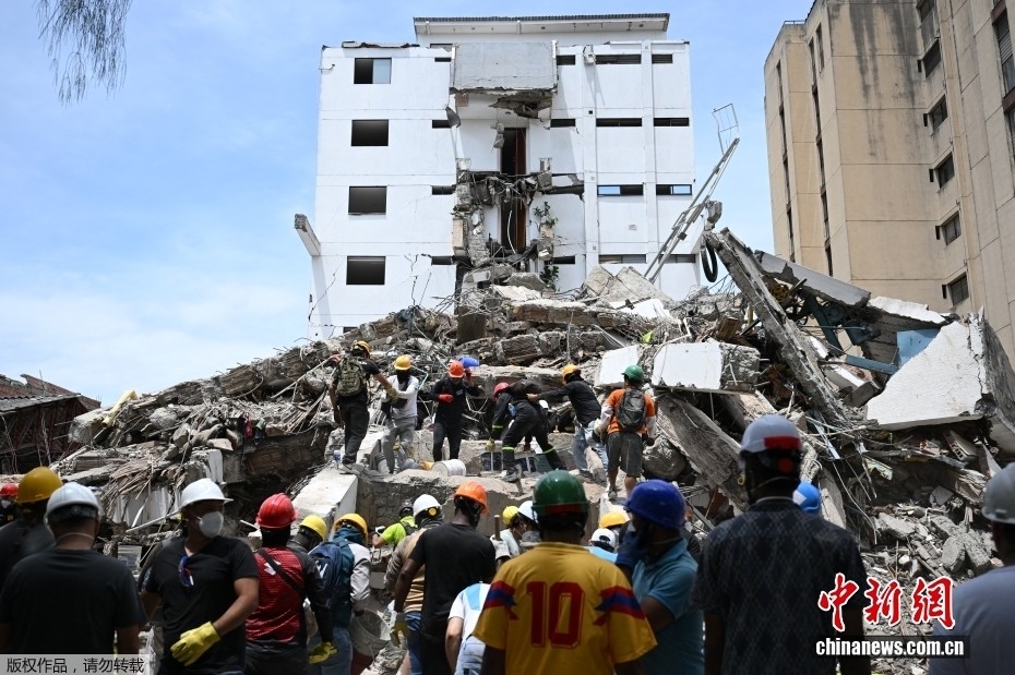 当地时间8月12日，哥伦比亚卡利，救援人员和志愿者在废墟中搜寻幸存者。