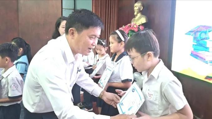 CEP微观金融组织新泰协分会经理潘公直向工人子女颁发奖学金。图：红桃
