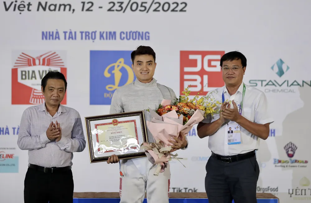 Thứ trưởng Bộ VH-TT-DL Hoàng Đạo Cương và Tổng cục trưởng Tổng cục TDTT Đặng Hà Việt trao bằng khen và hoa cho kiếm thủ Vũ Thành An. Ảnh: DŨNG PHƯƠNG