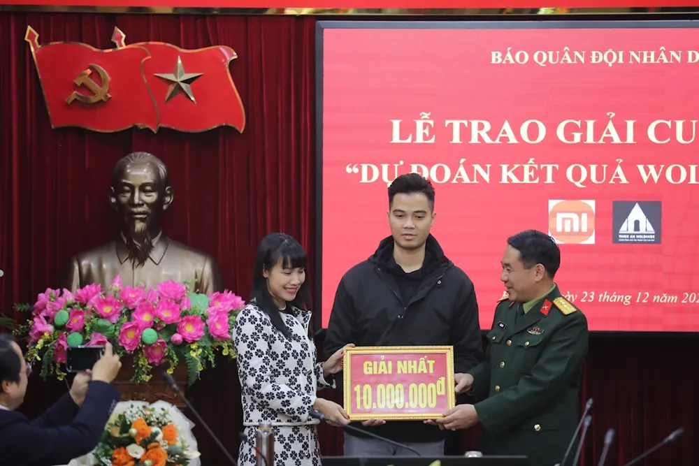 Ban biên tạp báo Quân đội Nhân dân trao thưởng cho độc giải đạt giải nhất cuộc dự đoán. Ảnh: H.T