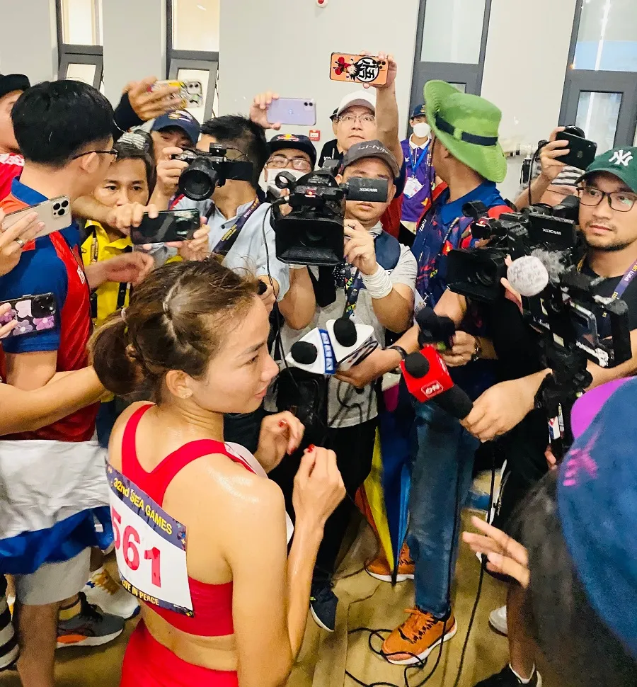 Các phóng viên thể thao Việt Nam tác nghiệp khi tuyển thủ điền kinh Nguyễn Thị Oanh vừa thi đấu xong nội dung của mình tại sân Morodok Techo (Campuchia). Ảnh: MINH MINH