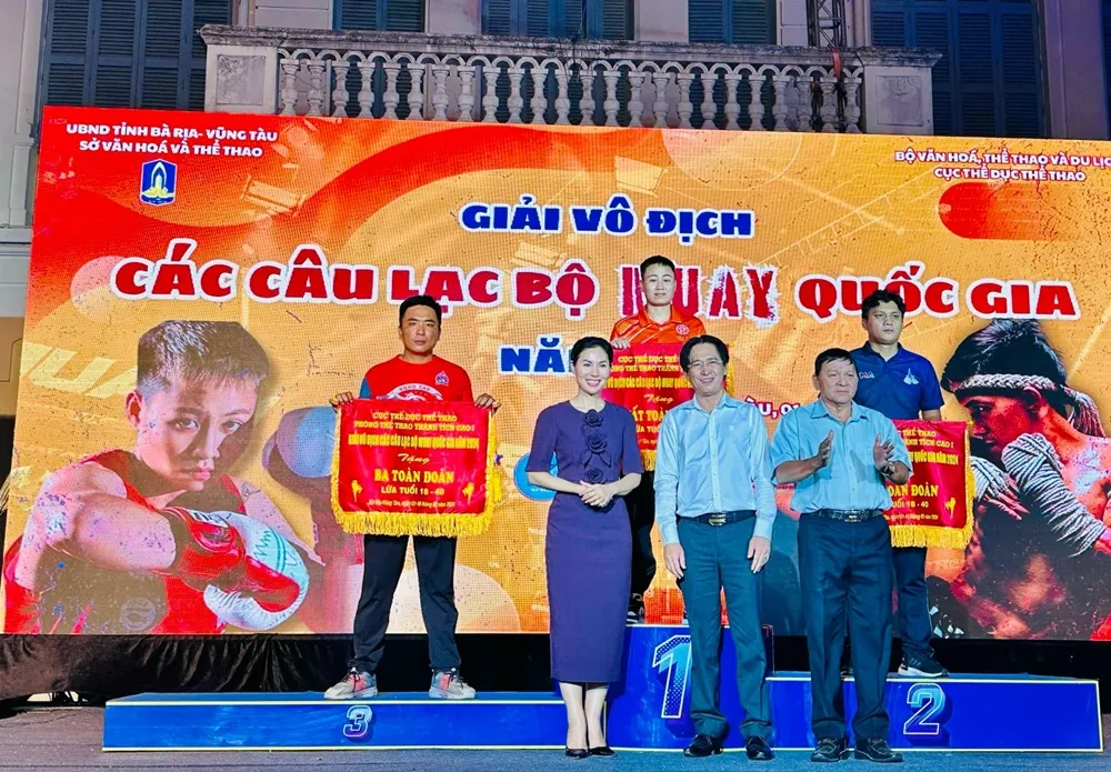 Ban tổ chức trao cờ lưu niệm cho các đoàn xếp ở nhóm đầu tổng sắp huy chương. Ảnh: MUAYVN