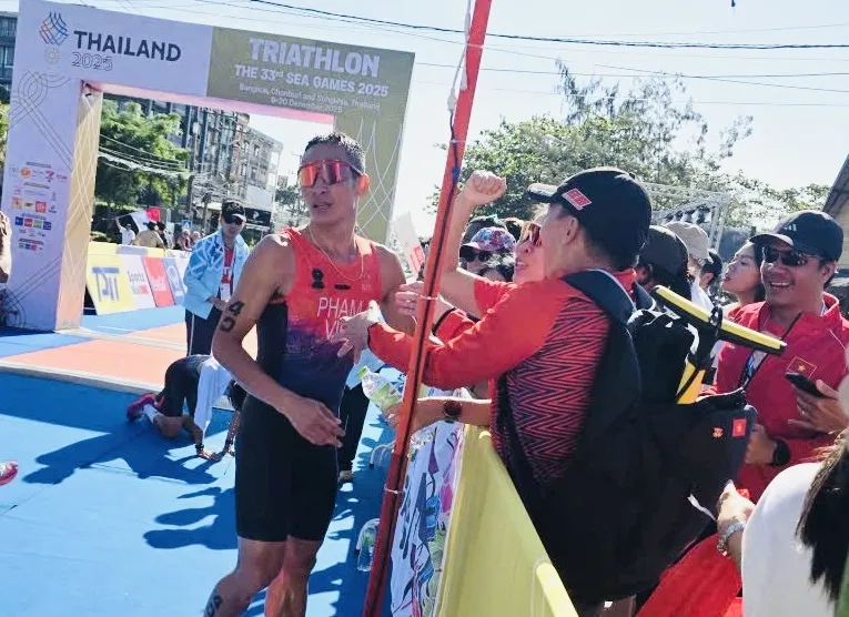 Phạm Tiến Sản được Ban huấn luyện đội tuyển triathlon Việt Nam chúc mừng khi hoàn thành chiến thắng giành HCV. Ảnh: MINH MINH