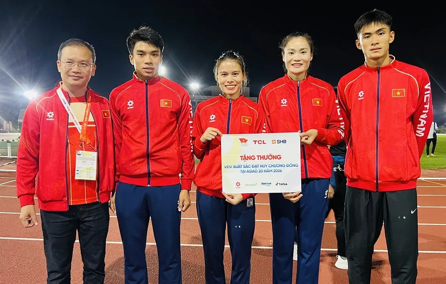 Trưởng đoàn Nguyễn Hồng Minh (ngoài cùng bên trái) động viên VĐV điền kinh Việt Nam giành HCĐ đầu tiên tại ASIAD 20. Ảnh: LƯỢNG LƯỢNG