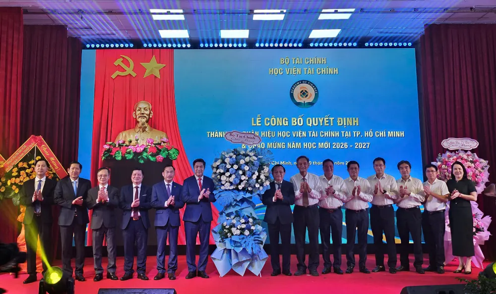 Thứ trưởng Bộ Tài chính Lê Tấn Cận cùng đoàn công tác tặng hoa chúc mừng Học viện Tài chính tại sự kiện.