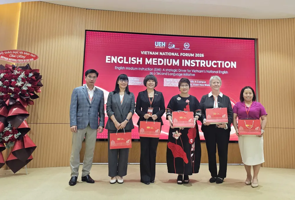 PGS-TS Bùi Quang Hùng, Giám đốc UEH (bìa trái), trao quà cám ơn các đại biểu, diễn giả tại sự kiện.