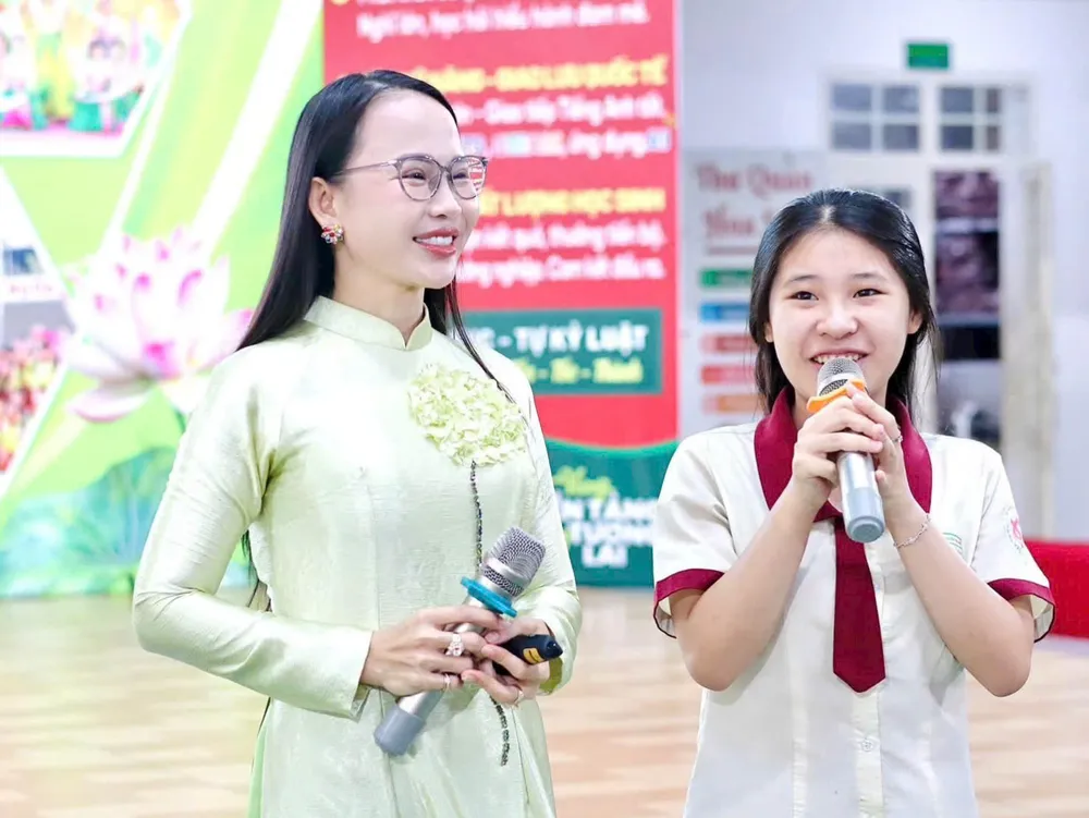 TS Nguyễn Thị Quốc Minh (trái) trong một buổi giao lưu, báo cáo chuyên đề về kỹ năng sống với học sinh.