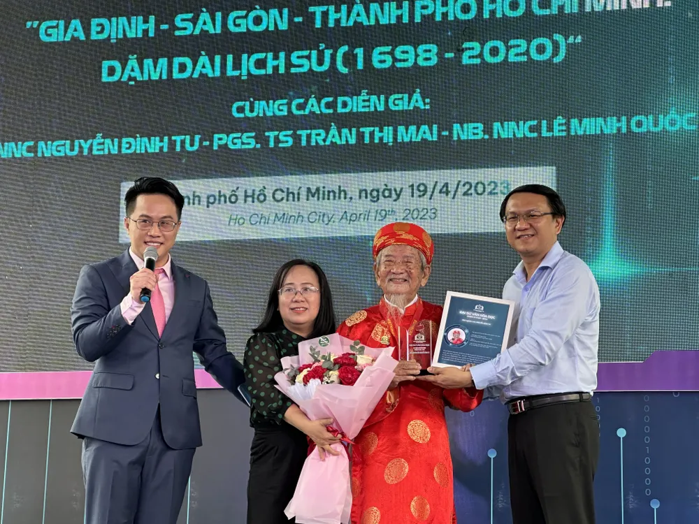 Bà Đinh Thị Thanh Thủy và ông Lâm Đình Thắng tặng hoa và biểu trưng Đại sứ Văn hóa đọc TPHCM nhiệm kỳ 2023-2024 cho nhà nghiên cứu Nguyễn Đình Tư